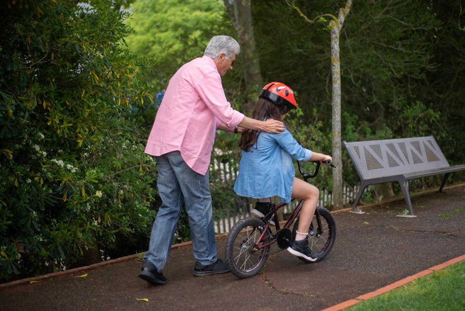 Happy child riding a colorful bicycle through a park with arms outstretched in joy